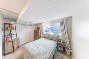 Bedroom featuring visible vents, a textured ceiling, a closet, and carpet flooring