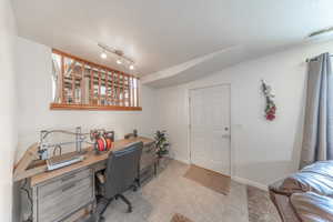 Office area with light tile patterned flooring, baseboards, visible vents, and a textured ceiling