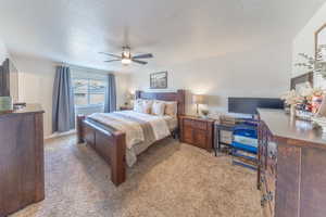 Bedroom with baseboards, carpet flooring, a textured ceiling, and a ceiling fan