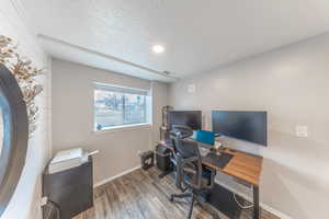 Office featuring visible vents, a textured ceiling, baseboards, and wood finished floors