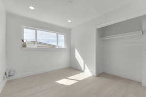 Unfurnished bedroom featuring a closet, baseboards, and wood finished floors