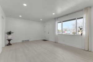 Unfurnished room with recessed lighting, light wood-style floors, and visible vents