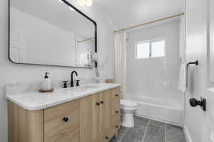 Bathroom with vanity, toilet, shower / bathtub combination with curtain, and tile patterned flooring