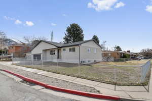 View of front facade with brick siding and a fenced front yard