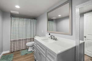 Bathroom featuring vanity, wood finished floors, visible vents, recessed lighting, and toilet