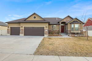View of front of house with a front lawn, fence, stucco siding, driveway, and an attached garage