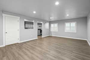 Unfurnished living room with recessed lighting, light wood-style flooring, and baseboards