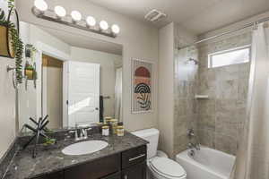 Bathroom featuring visible vents, toilet, shower / tub combo, a textured ceiling, and vanity