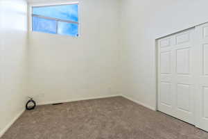 Unfurnished bedroom featuring visible vents, baseboards, and carpet flooring