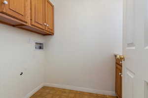 Laundry area with cabinet space, hookup for a washing machine, and baseboards