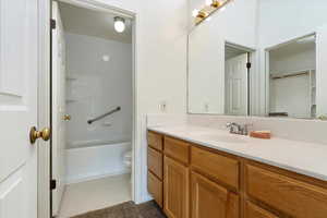 Full bathroom with toilet, vanity, and tile patterned flooring