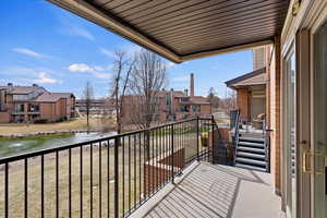 Balcony featuring a residential view and a water view