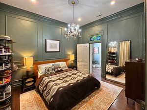 Bedroom with a decorative wall, visible vents, and ornamental molding