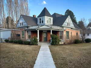 View of front of house with a porch and brick siding
