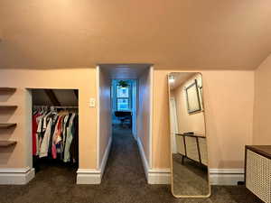 Hallway with baseboards and carpet floors