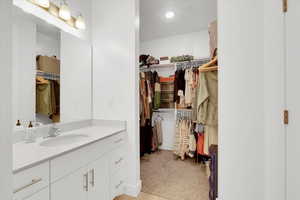 Full bath featuring a spacious closet and vanity