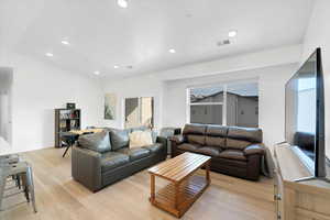 Living area featuring recessed lighting, visible vents, and light wood-style flooring