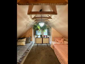 Bedroom with access to exterior, vaulted ceiling with beams, and carpet
