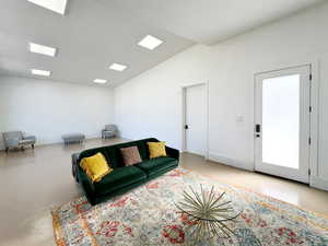 Living area with vaulted ceiling and finished concrete floors