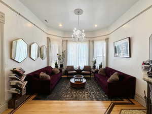 Living room featuring a notable chandelier, wood finished floors, and visible vents