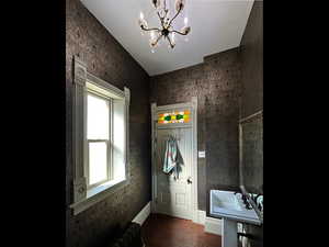 Bathroom featuring a chandelier, radiator heating unit, baseboards, and wood finished floors