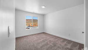 Carpeted spare room featuring baseboards and a textured ceiling