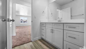 Bathroom featuring visible vents, baseboards, wood finished floors, and vanity