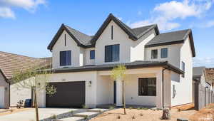 Modern farmhouse style home with a tiled roof, stucco siding, driveway, and a garage