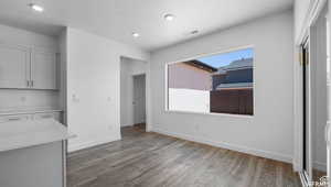 Unfurnished dining area featuring recessed lighting, visible vents, baseboards, and wood finished floors