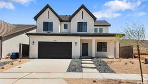 Modern inspired farmhouse featuring stucco siding, driveway, a porch, an attached garage, and a tiled roof