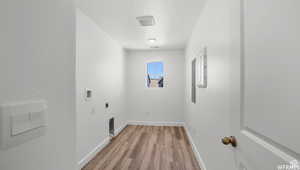 Laundry room with washer hookup, laundry area, light wood-style flooring, hookup for an electric dryer, and a textured ceiling