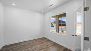 Unfurnished room featuring recessed lighting, visible vents, baseboards, and dark wood finished floors