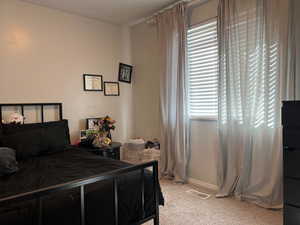 Bedroom featuring light colored carpet and visible vents