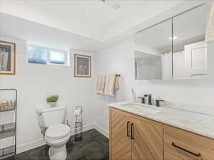 Bathroom with visible vents, baseboards, toilet, and vanity