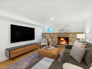 Living room with recessed lighting, baseboards, wood finished floors, and a fireplace