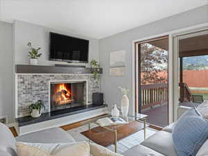 Living room with visible vents, a fireplace, baseboards, and wood finished floors