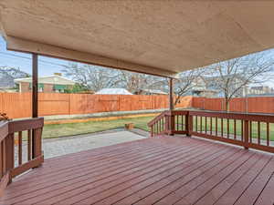 Wooden deck featuring a lawn and a fenced backyard