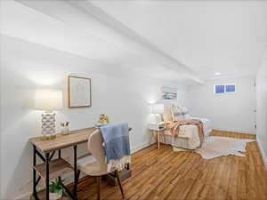 Bedroom featuring visible vents, baseboards, and wood finished floors