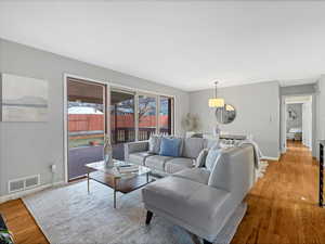 Living area featuring light wood-style flooring, baseboards, and visible vents