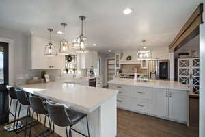 Kitchen featuring a sink, stainless steel appliances, white cabinets, and light countertops