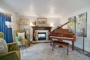 Living area with baseboards and a glass covered fireplace