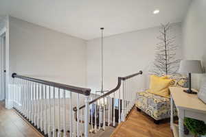 Stairway with recessed lighting and wood finished floors