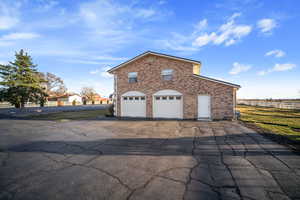 View of side of home with brick siding, driveway, and a garage