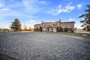 View of front facade featuring a front lawn, fence, driveway, and a chimney