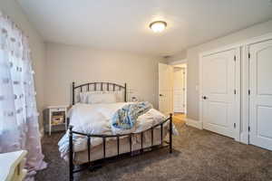 Bedroom with carpet flooring, visible vents, baseboards, and a textured ceiling