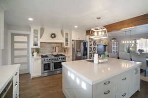 Kitchen with custom exhaust hood, recessed lighting, dark wood-type flooring, and appliances with stainless steel finishes