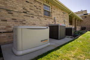 Exterior details with cooling unit, a power unit, and brick siding