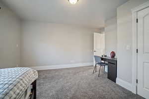 Carpeted bedroom with baseboards and a textured ceiling