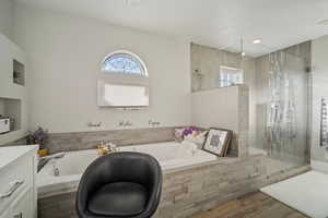 Full bath featuring vanity, wood finished floors, visible vents, a shower stall, and a bath