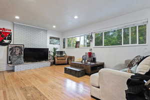 Living room with recessed lighting, a textured ceiling, and hardwood / wood-style flooring